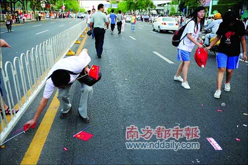 圣火传递后的街道，国旗和垃圾被丢弃满地